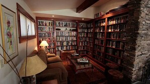 A cozy library with bookshelves, a comfortable sofa, and a lamp. - Private Island in Big Sky-Great Fishing & Hunting (Big Sky)
