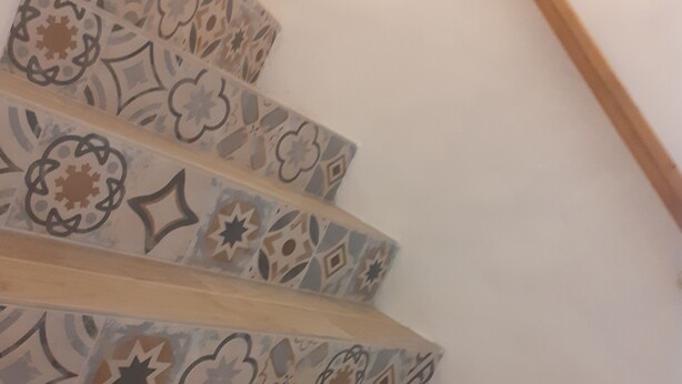 A staircase with patterned tiles and wooden steps. - At the foot of Mont Ventoux<br>Village center<br>Fully renovated apartment<br> (Malaucène)