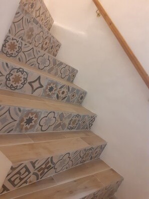 A staircase with patterned tiles and wooden steps. - At the foot of Mont Ventoux<br> Village center<br> Fully renovated apartment<br> (Malaucène)