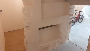 A room with a partially constructed wall, a wooden floor, and a red bicycle in the background. - At the foot of Mont Ventoux<br>Village center<br>Fully renovated apartment<br> (Malaucène)