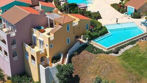 A residential area with a swimming pool, multiple houses with red-tiled roofs, and a central courtyard. - Stunning Resort Apartment at Las Casitas (Fajardo)