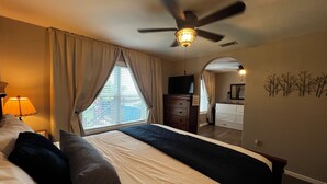 A bedroom with a bed, a dresser, a ceiling fan, a TV, and a window with curtains. - Fisherman’s Getaway with Sunset Views & Room for 11 (Jewett)