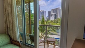A balcony with a view of tall buildings and palm trees. - Minutes to Beach | Pool+Gym | WFH Station | Lanai (Honolulu)