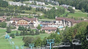 A ski resort with multiple buildings, a ski lift, and a pool area.