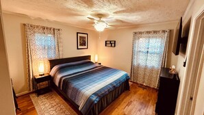 A bedroom with a bed, nightstands, a ceiling fan, a rug, and a dresser. - Little House in Jasper (Jasper)