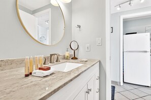 Bañera con ducha, toallas, jabón, shampoo