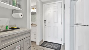 A modern kitchen with white cabinets, a marble countertop, and a built-in oven. - Waterfront Condo w/Pool Access (Fort Walton Beach)