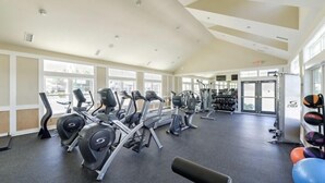 Un gimnasio con cintas de correr, elípticas y equipo de pesas.