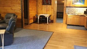 Un interior de madera con comedor, cocina y zona de estar.