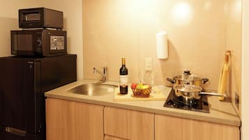Una cocina con refrigerador, microondas, fregadero y estufa.