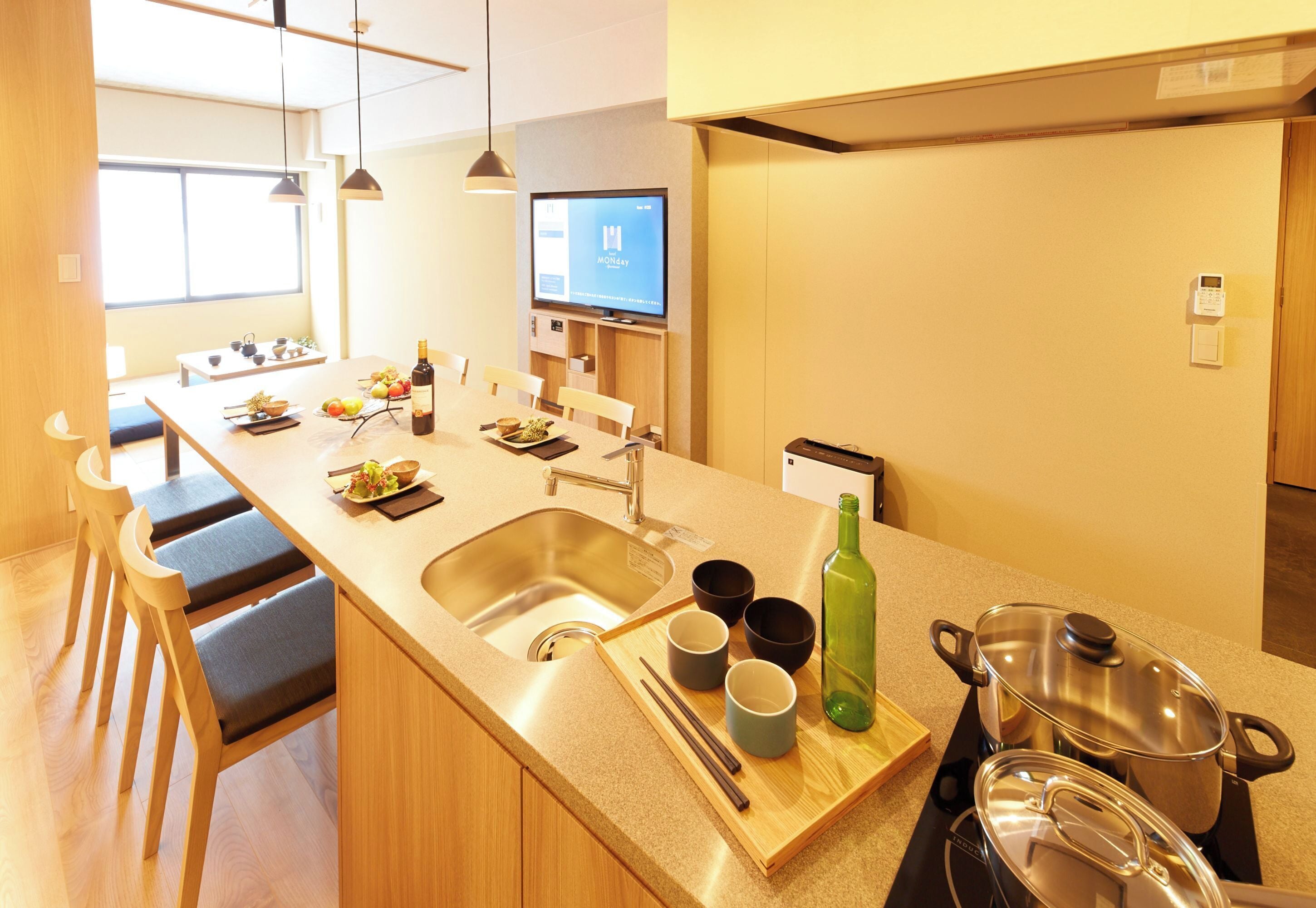 Una cocina moderna con una isla grande, un fregadero y un comedor con sillas y una mesa.