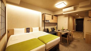 A hotel room with two beds, a desk, and a chair.