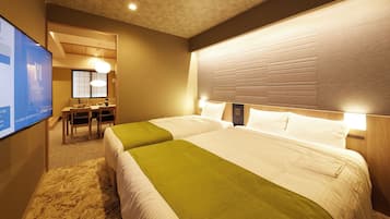 A hotel room with two beds, a desk, and a television.