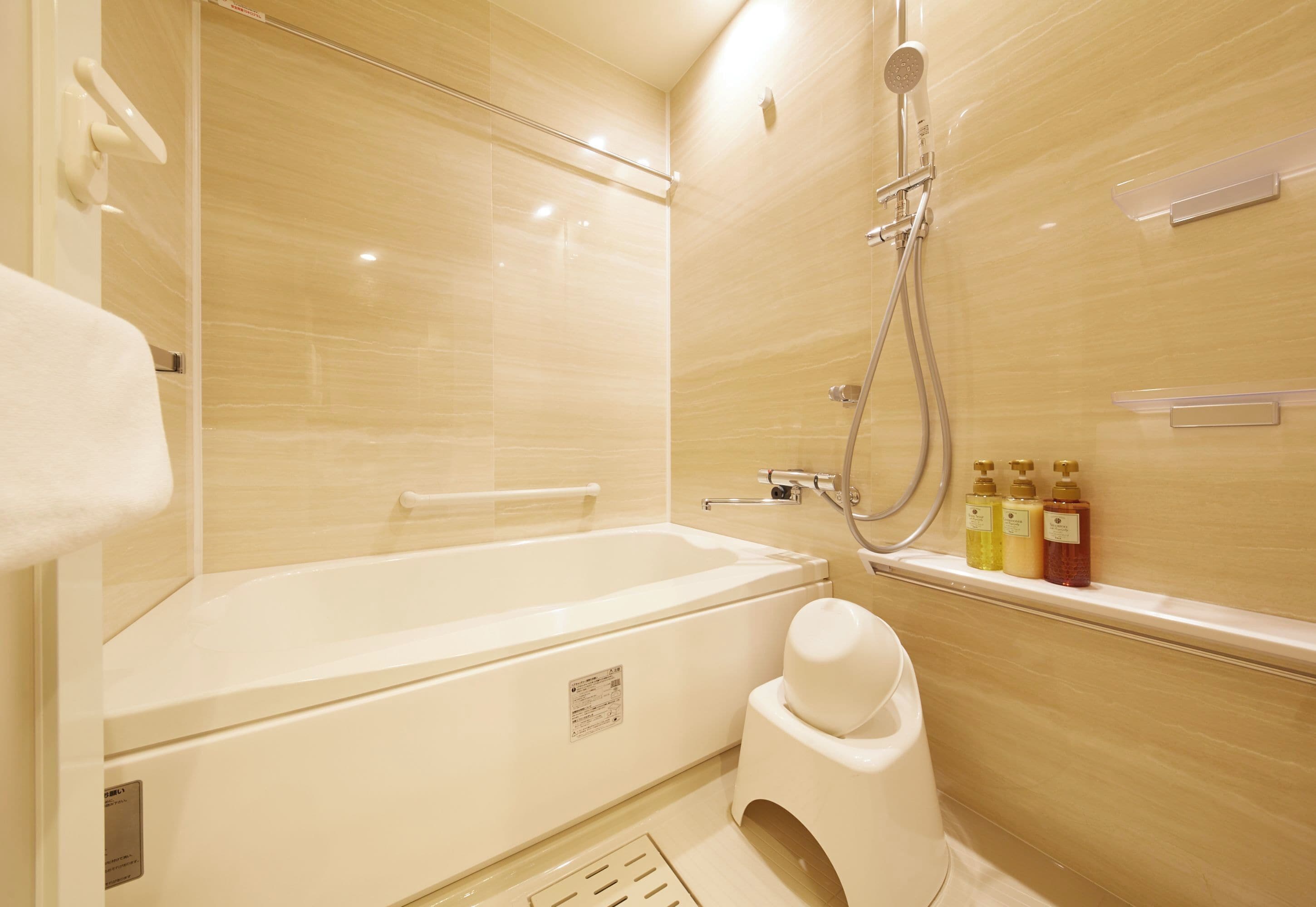 A modern bathroom with a bathtub, shower, and toilet.