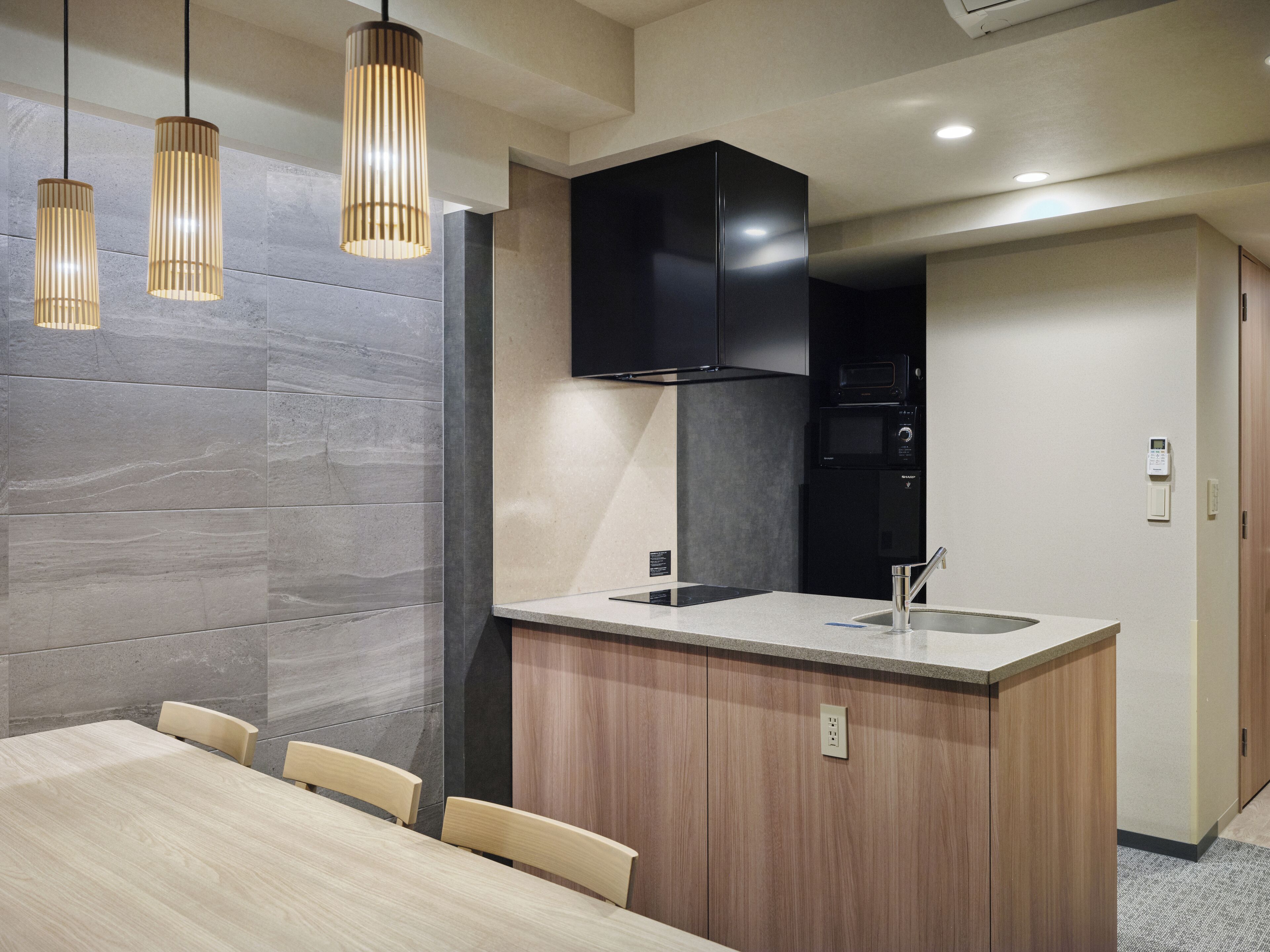 Una cocina moderna con una isla central, armarios de madera y un microondas negro.