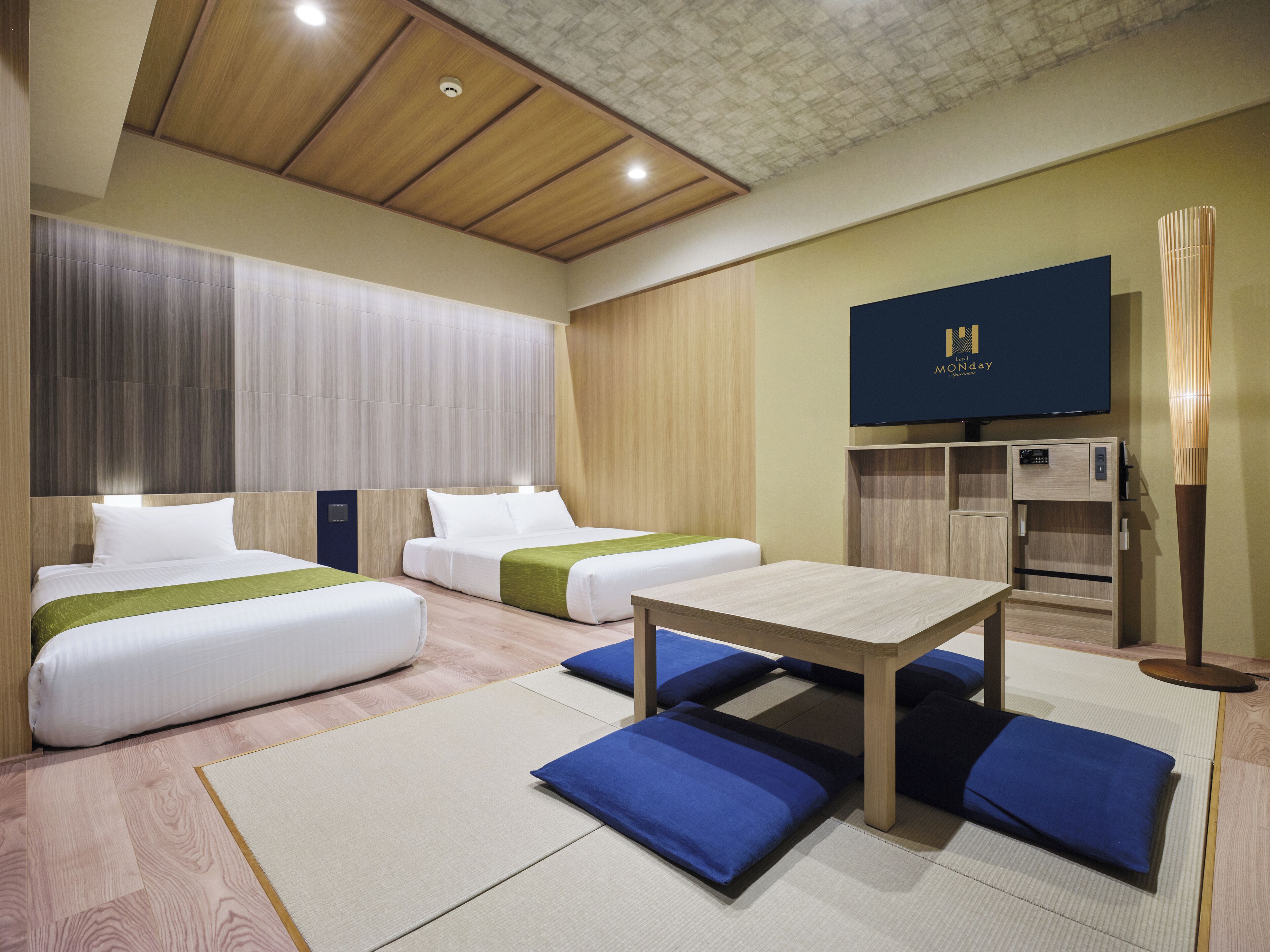 Une chambre d’hôtel avec deux lits, une télévision, un bureau et un mini-bar.