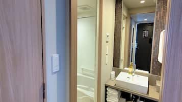 Un baño moderno con un lavamanos blanco, un espejo y un perchero para toallas.
