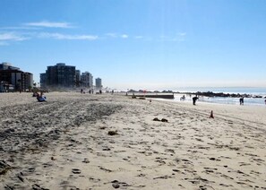 A beach with footprints, a pier, and buildings in the background. - Beautiful BOHO Home by Beach, Downtown + Shops (San Diego)
