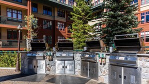 Un espace patio avec des barbecues d’extérieur et un mur en pierre.