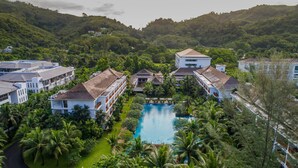 A resort with multiple buildings, a central swimming pool, and lush greenery. - Naithonburi Beach Resort (Sa Khu)