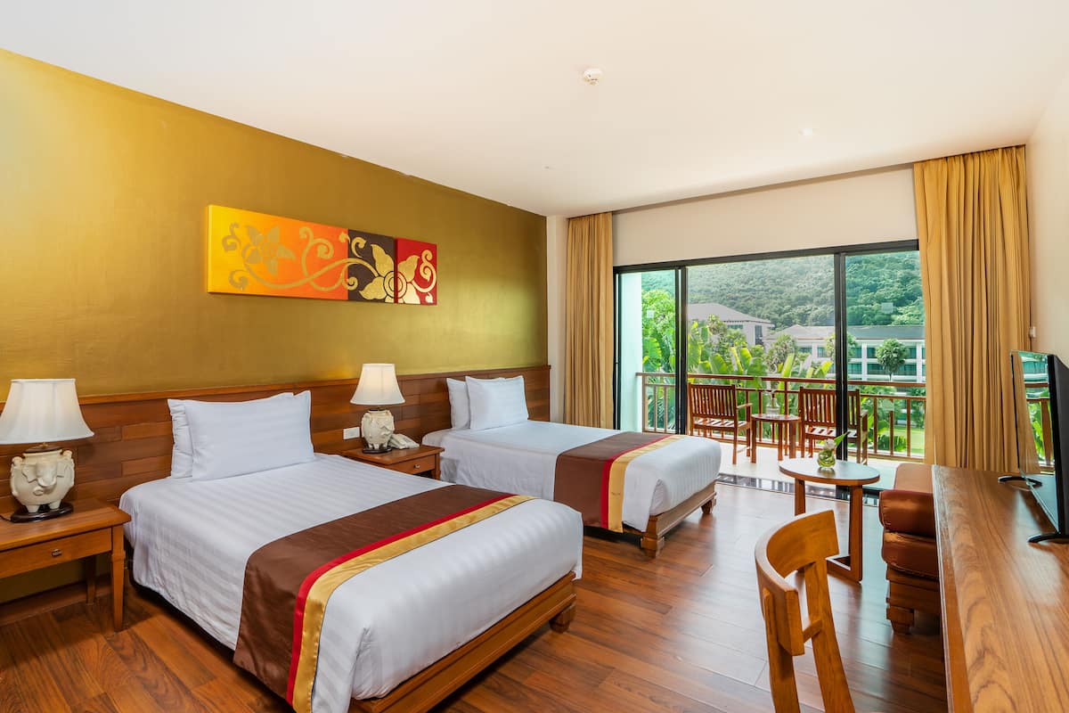 Ein Hotelzimmer mit zwei Betten, Holzboden, einem Balkon mit Blick und einem Fernseher.