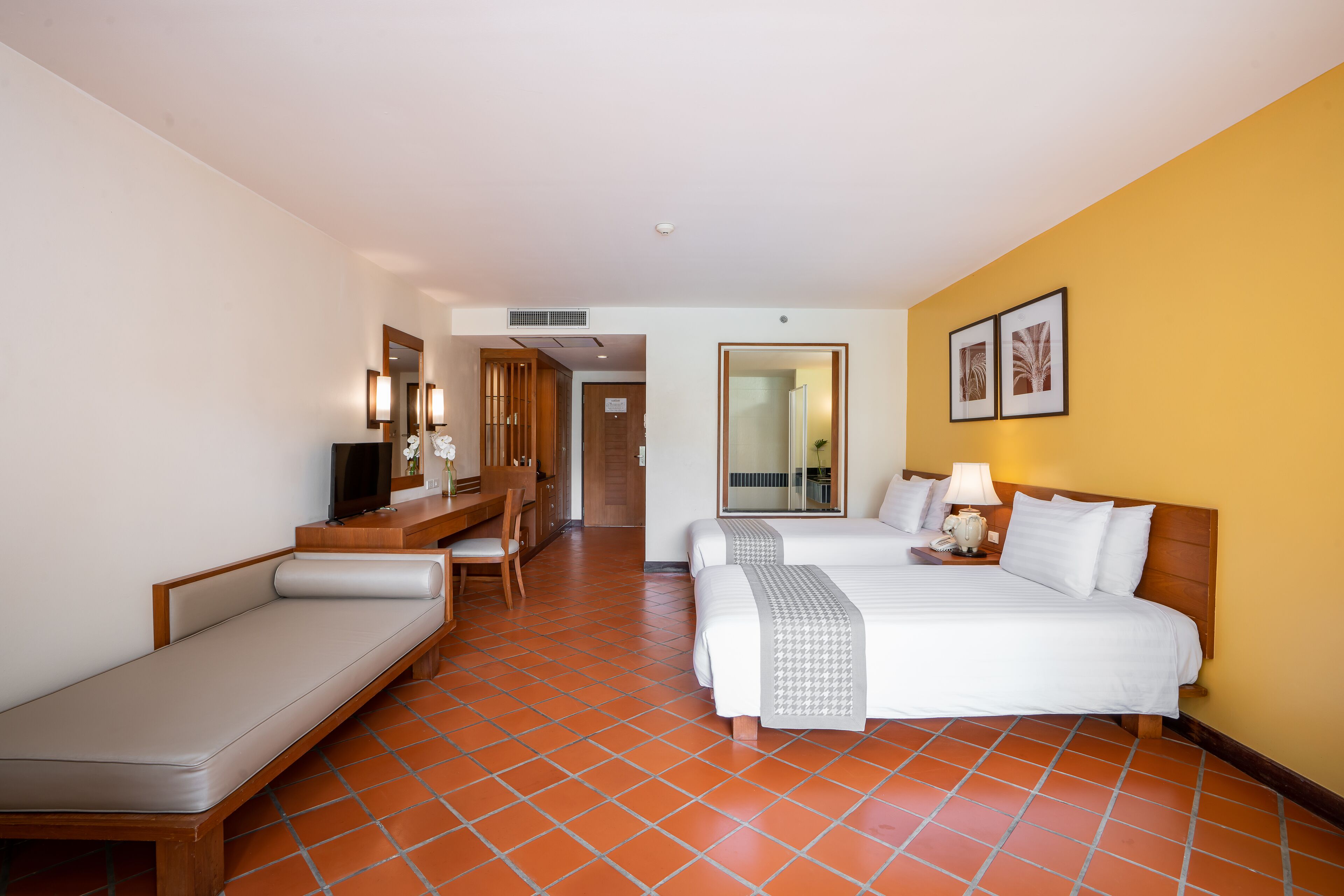 Una habitación de hotel con cama, sofá, escritorio y televisión.