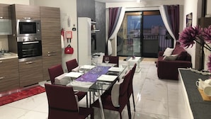 Un appartement moderne comprenant un coin repas, une cuisine et un balcon.