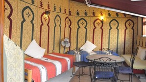 A room with a bed, two chairs, a small table, and a fan. - Appartement Typique Casbah Tanger Lieu Historique (Tangier)