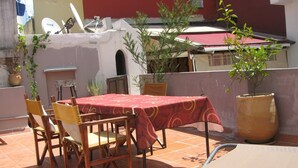 A patio with a table and chairs, potted plants, and a satellite dish. - Appartement Typique Casbah Tanger Lieu Historique (Tangier)