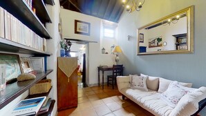 A cozy living room with a sofa, a table with a lamp, and a bookshelf. - Tenerife Village Finca Paraiso (San Cristóbal de La Laguna)
