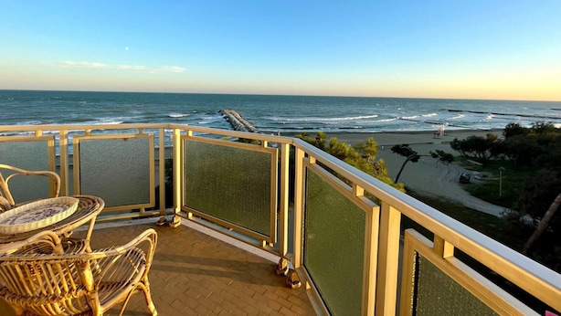 A balcony with wicker furniture overlooking the ocean. - Wonderful Beachfront Apartment-beahost (Caorle)
