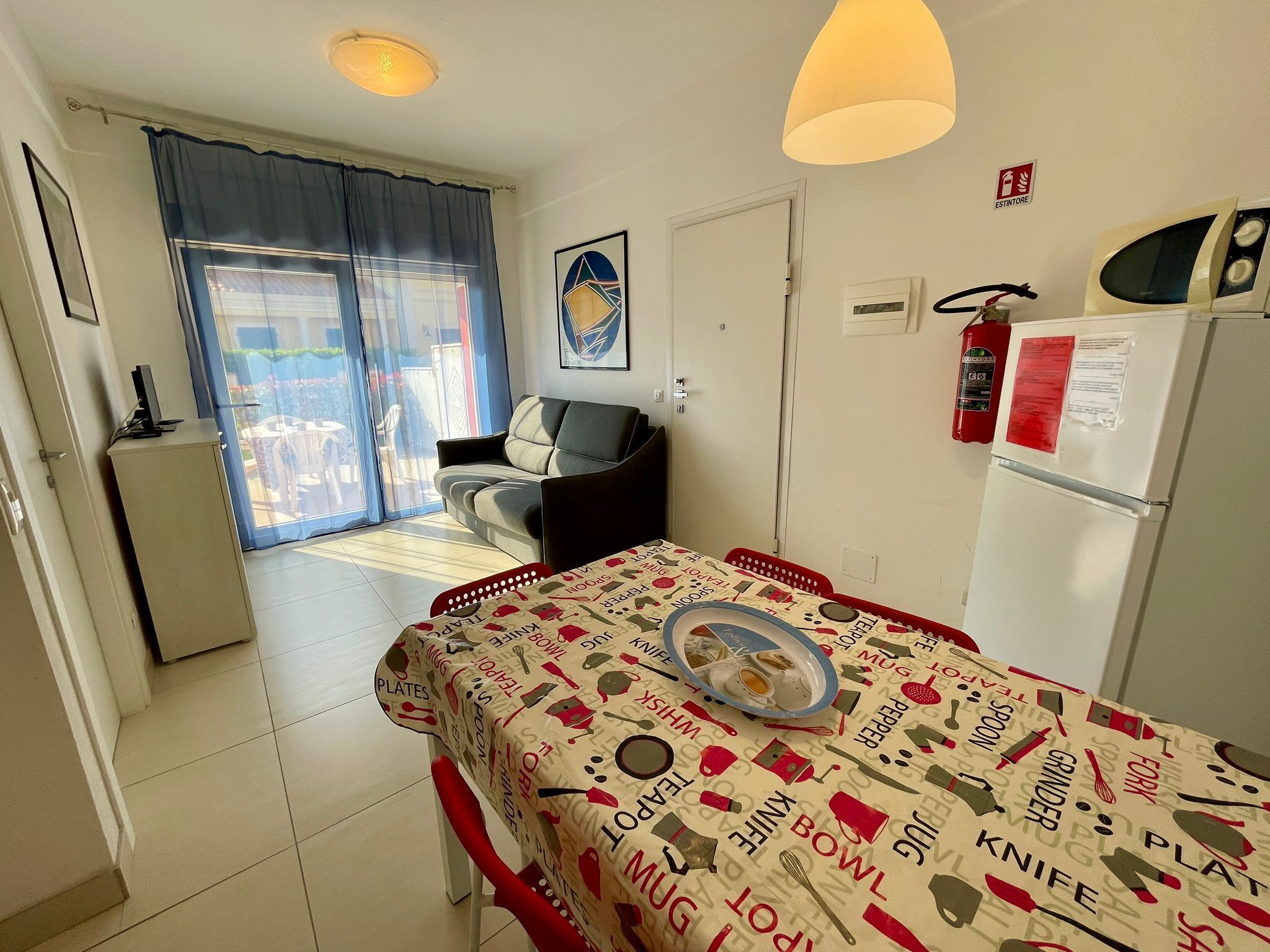Un espacio habitable compacto con mesa de comedor, kitchenette y sofá.