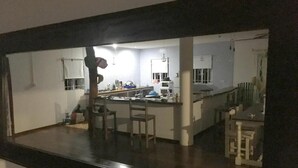 A kitchen with a central island, bar stools, and a refrigerator. - Casa Livingston - Luxury Villa - La Digue Seychelles (La Digue)