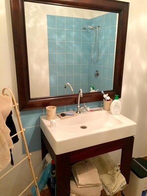 A bathroom with a white sink, a mirror, and a blue tiled wall. - Casa Livingston - Luxury Villa - La Digue Seychelles (La Digue)