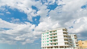 A multi-story building with balconies, under a partly cloudy sky. - Bluemarine Apartment (Gallipoli)