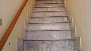 Eine Marmortreppe mit Holzhandläufen.