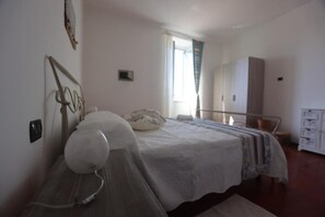 Ein Schlafzimmer mit Bett, Nachttisch und Kleiderschrank.