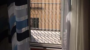 Ein Zimmer mit Blick durch eine Glastür auf einen Balkon mit Metallgeländer.