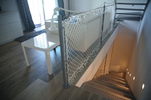 Un escalier doté d’une rambarde de sécurité blanche et d’un plancher en bois.