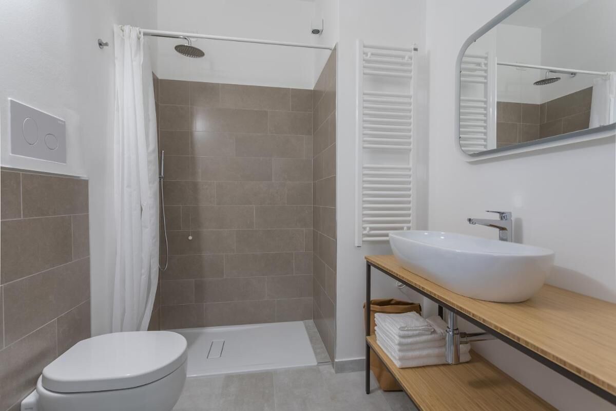 Un baño moderno con ducha, inodoro y tocador.