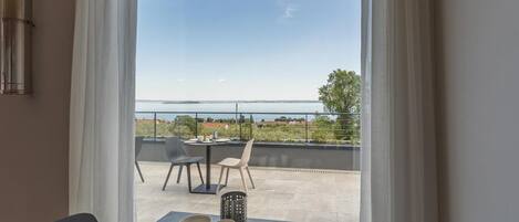 A dining area with a view of the sea and a balcony with outdoor seating.