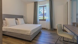 Un dormitorio con cama, escritorio y silla.