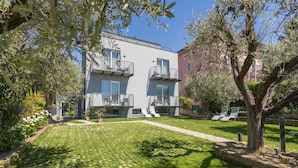 Un bâtiment moderne doté de balcons, d’une pelouse bien entretenue et d’un espace extérieur aménagé pour s’asseoir.