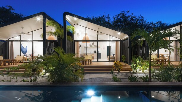 Une maison moderne dotée d’une piscine, d’un espace salon extérieur et d’un patio.