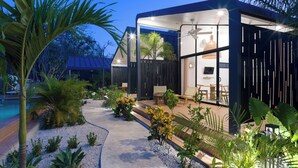 Une maison moderne dotée d’une piscine, d’un espace salon extérieur et de plantes tropicales.