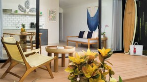 A modern living space with a glass door leading to a kitchen, a dining area with a round table, and a seating area with a sofa. - 3 Favela Chic Tamarindo Adults Only Bungalow (Tamarindo)