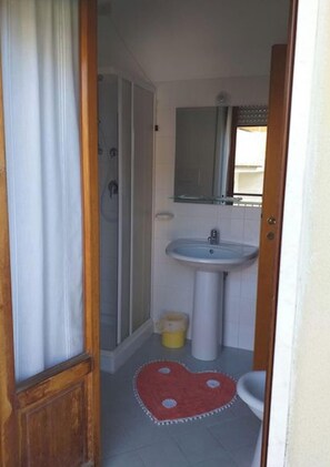 A bathroom with a shower, sink, and toilet. - Room-spacious Triple Room a Stones Throw (Pineto)
