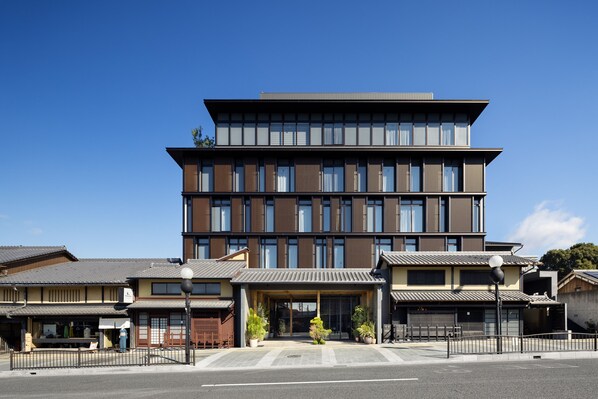 A modern building with a traditional entrance, featuring a covered walkway and potted plants. - Nohga Hotel Kiyomizu Kyoto (Kyoto)
