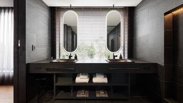Une salle de bain moderne avec deux lavabos, des carreaux de couleur sombre et une fenêtre équipée de stores.