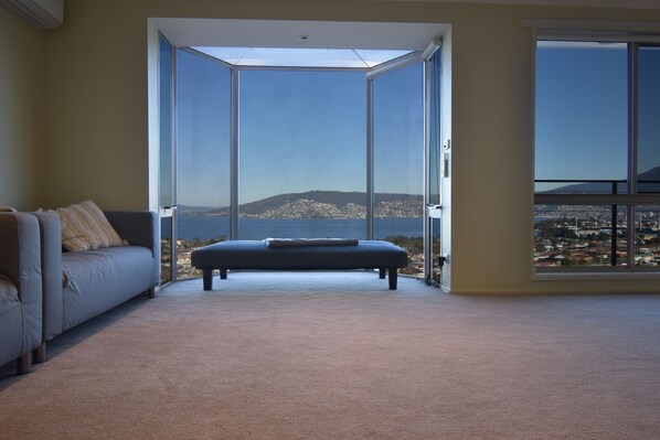 A room with a large sliding glass door leading to a balcony with a city view.
